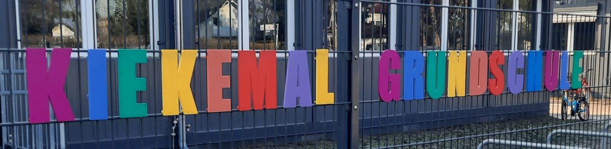 Schulname am Zaun der Filiale